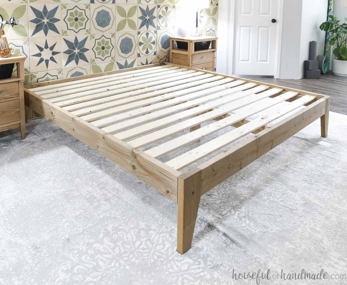 DIY bed frame built from 2x4 and 2x6 boards without a mattress on it.